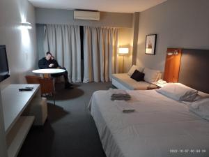 a person sitting at a table in a hotel room at Buenos Aires Apartamento in Buenos Aires