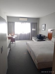 ein Hotelzimmer mit einem großen Bett und einem Schreibtisch in der Unterkunft Buenos Aires Apartamento in Buenos Aires