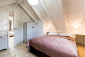 a bedroom with a large bed in a attic at Domki Cicha Struga in Chocieszow