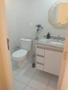uma casa de banho com um WC, um lavatório e um espelho. em Ap smart Campinas em Campinas