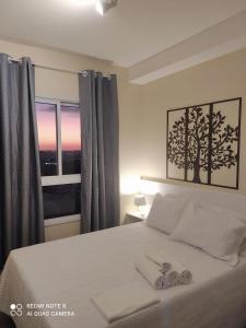 um quarto com uma cama com duas toalhas em Ap smart Campinas em Campinas
