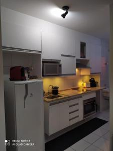 uma cozinha com armários brancos e um saco vermelho no balcão em Ap smart Campinas em Campinas