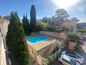 a house with a swimming pool in a parking lot at La Digue, 2 chambres, vue mer et piscine in La Seyne-sur-Mer