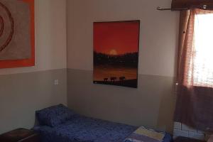 a room with a bed and a painting on the wall at negev ein habsor עין הבשור דרום in Ein HaBesor