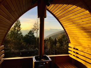 an arched window in a cabin with a view of the mountains at Minds & Mountains Eco Lodge in La Molina