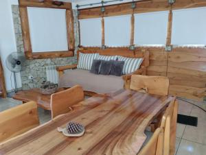 sala de estar con mesa de madera y sofá en Cabaña en Valeria del Mar en Cariló