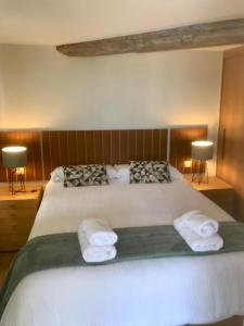 una camera da letto con un grande letto con asciugamani di KAI GANE Excepcional apartamento puerto viejo de Bermeo a Bermeo