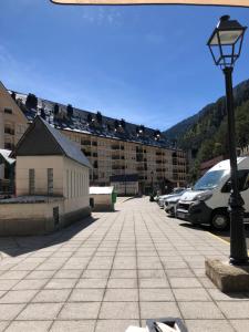 ein Parkplatz mit einem Gebäude und einer Straßenbeleuchtung in der Unterkunft Ático europa, Canfranc estación in Canfranc-Estación