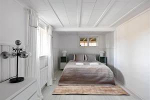 een witte slaapkamer met een bed en een raam bij Peaceful family home with indoor fireplace in Åkersberga