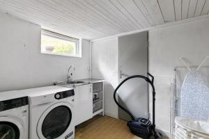 een wasruimte met een wasmachine en een wastafel bij Peaceful family home with indoor fireplace in Åkersberga