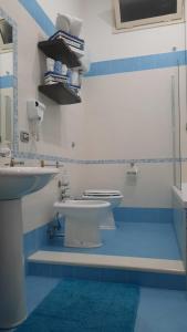 a blue and white bathroom with a toilet and a sink at White Home Quartieri Spagnoli in Naples