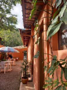 a building with a patio with a table and an umbrella at SUÍTES ITABERABA BOIÇUCANGA in Boicucanga