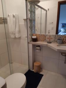 uma casa de banho com um WC, um lavatório e um espelho. em Pousada Manacás em Cavalcante