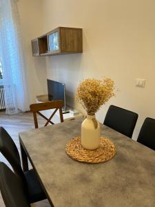 a vase with flowers sitting on top of a table at Casa D'Aria in Savona