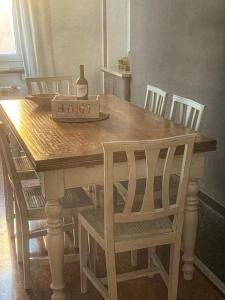 una mesa de madera con sillas y una caja en ella en La dimora del capitano en Génova