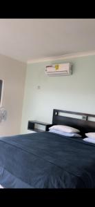 een slaapkamer met een bed met een blauwe deken bij Mountain Beach View, Apartments in Sandhills Hellshire in Braeton
