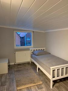 a bedroom with a bed and a window at Wohnung am Wasserturm in Ilsede