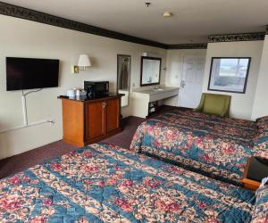 um quarto de hotel com duas camas e uma televisão em Bayview Inn em Crescent City