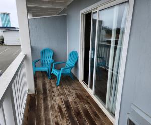 Dos sillas azules sentadas en el balcón de una casa en Bayview Inn, en Crescent City