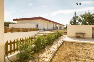 a building with a fence and a table in front of it at Tenuta Gurgo in Bitonto