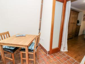 - une salle à manger avec une table et des chaises en bois dans l'établissement Ty Taid, à Gaerwen