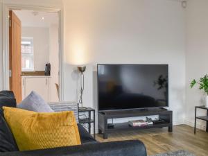 a living room with a large flat screen tv at Pickwood Gatehouse in Leek