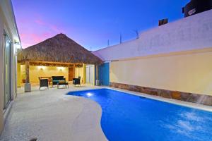 a villa with a swimming pool in front of a house at DT La Paz Condos with Pool & Palapa Lounge, 2 mi to Malecón in La Paz