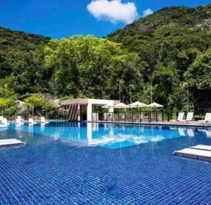 una gran piscina con una montaña en el fondo en Apartamentot perfeito, aconchegante e com Clube, en Río de Janeiro