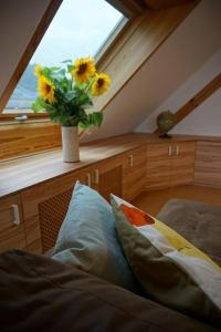 a bedroom with a window with a vase with sunflowers at Apartment mit Ausblick im Dresdner Südwesten in Dresden