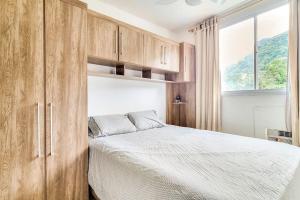 1 dormitorio con cama y ventana grande en Apartamentot perfeito, aconchegante e com Clube, en Río de Janeiro