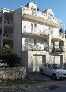 un coche blanco estacionado frente a un edificio en Apartments Vlasic, en Ston