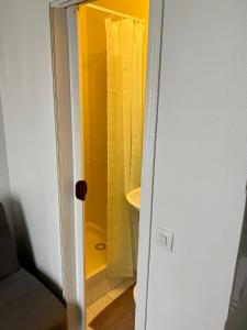 baño con ducha con cortina amarilla en Home Sweet Home Montmartre Duperre en París