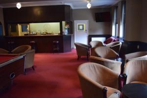 a waiting room with a pool table and chairs at Rossmore Hotel in Ilford