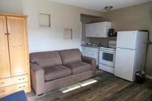 uma sala de estar com um sofá e um frigorífico branco em Richter Pass Beach Resort em Osoyoos