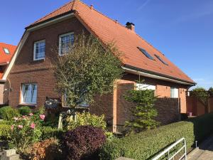 a brown brick house with a red roof at Nordseekrabbe Bollmann in Carolinensiel