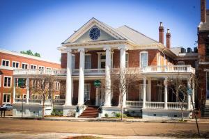 The Guest House Historic Mansion في ناتشيز: مبنى من الطوب كبير وبه اعمدة بيضاء