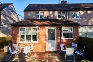 a patio with chairs and a table in front of a house at Spacious house, private garden, parking & Netflix in Derby