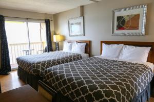 オソヨースにあるRichter Pass Beach Resortのベッド2台と窓が備わるホテルルームです。
