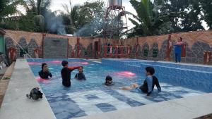 un groupe de personnes dans une piscine dans l'établissement AFS Suites Barra, Opol, à Cagayán de Oro