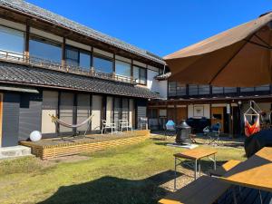 - un bâtiment avec une terrasse dotée d'un hamac en face dans l'établissement HIKE, à Nirasaki