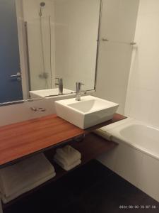 Buenos Aires Apartamento في بوينس آيرس: حمام مع حوض ومرآة وحوض استحمام