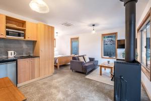 een keuken en een woonkamer met een houtkachel bij Freycinet Stone Studio 8 - Sandstone in Coles Bay