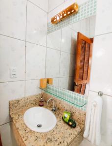 a bathroom with a sink and a mirror at Pousada Aquarela do Mar in Abraão