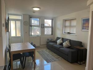 a living room with a couch and a table at Lovely 2 Bedroom 2 Bathroom Apartment with Parking in Loughborough