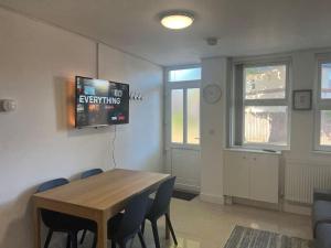 a dining room with a table and a tv on the wall at Lovely 2 Bedroom 2 Bathroom Apartment with Parking in Loughborough