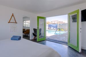 - une chambre avec un lit et une vue sur la piscine dans l'établissement Desert Hot Springs Inn, à Desert Hot Springs