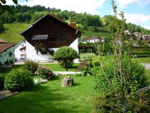 a house with a yard with bushes and flowers at Gîte confortable à La Bresse, proche centre-ville, nature et activités - FR-1-589-97 in La Bresse