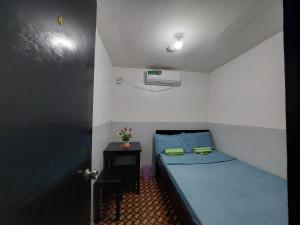 mały pokój z niebieskim łóżkiem i stołem w obiekcie Maui's Place w mieście Badian
