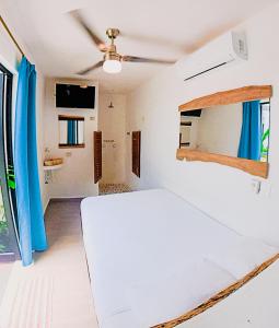 1 dormitorio con 1 cama y ventilador de techo en Ade Hotel Bacalar en Bacalar