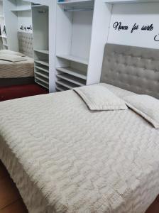 ein Schlafzimmer mit zwei Betten und einem Kopfteil in der Unterkunft Apartamento Bella Vista Gramado in Gramado